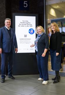 Das Foto zeigt Hans Thomas Kessler, Sabine Leutheusser-Schnarrenberger und Dr. Kathrin Pieren vor einem Screen, auf dem das Motiv zur Antwort auf die Frage „Wer, was oder wo ist Jom Kippur?“ gezeigt wird.